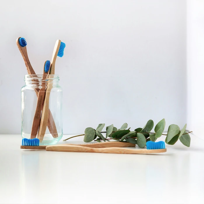 image of toothbrushes in a jar on a desk